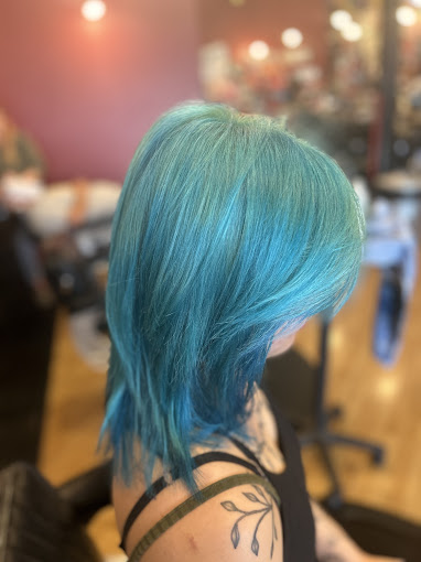 A woman with blue hair sitting in a chair