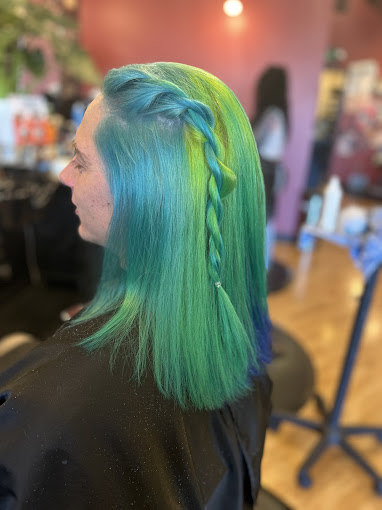 A woman with green and blue hair in a salon