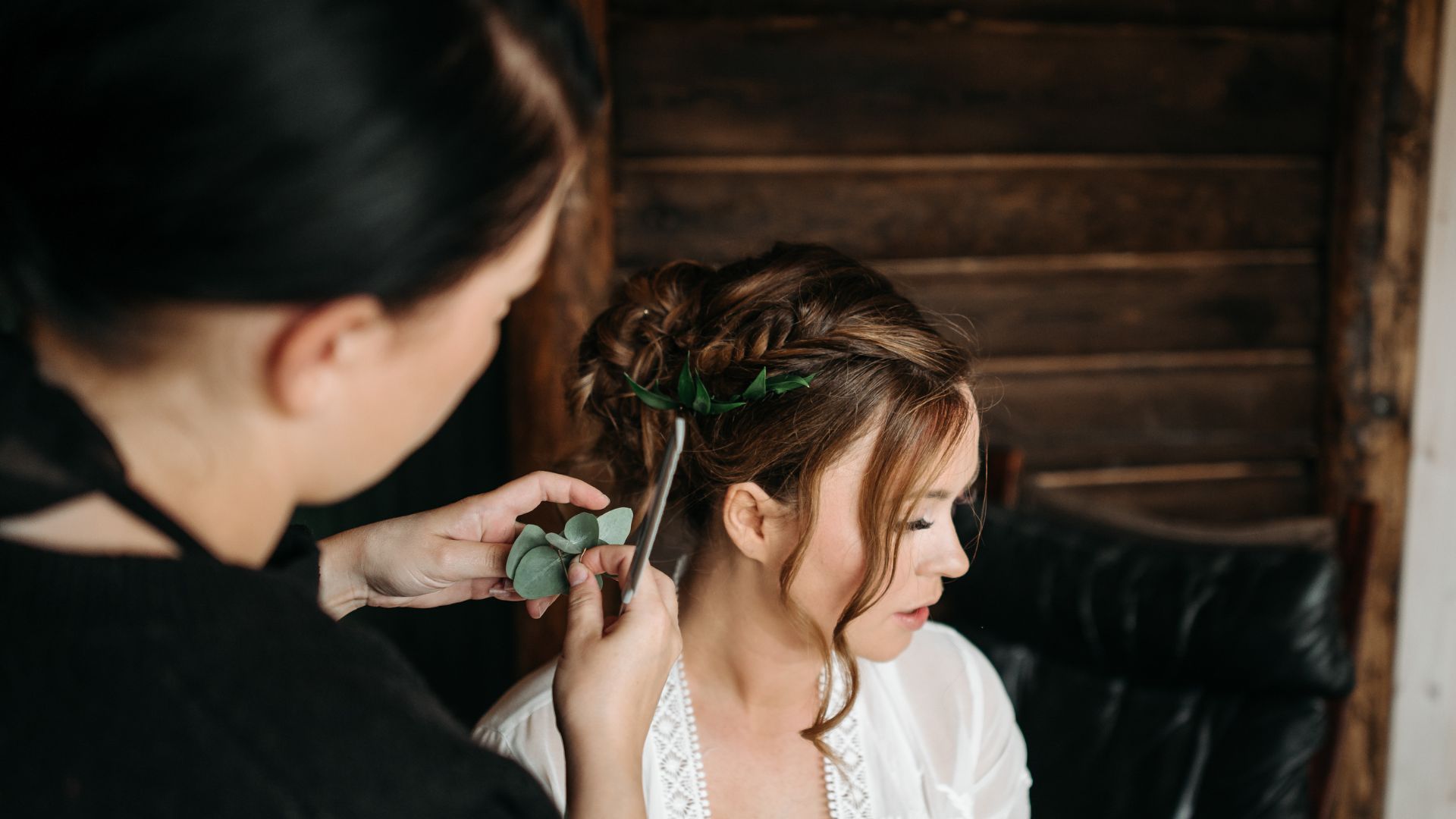 A woman is getting her hair done by a woman